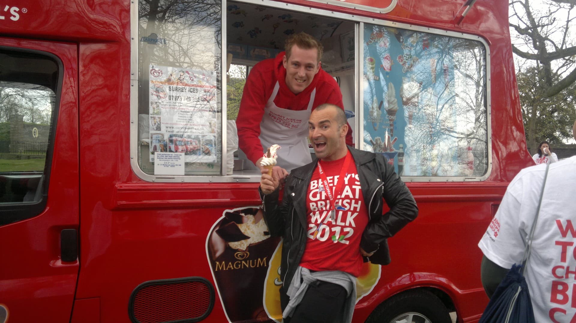 A man in a red Hampshire Ices hoodie serving from a red van while a walker holds a cone during Beefy's Great British Walk 2012