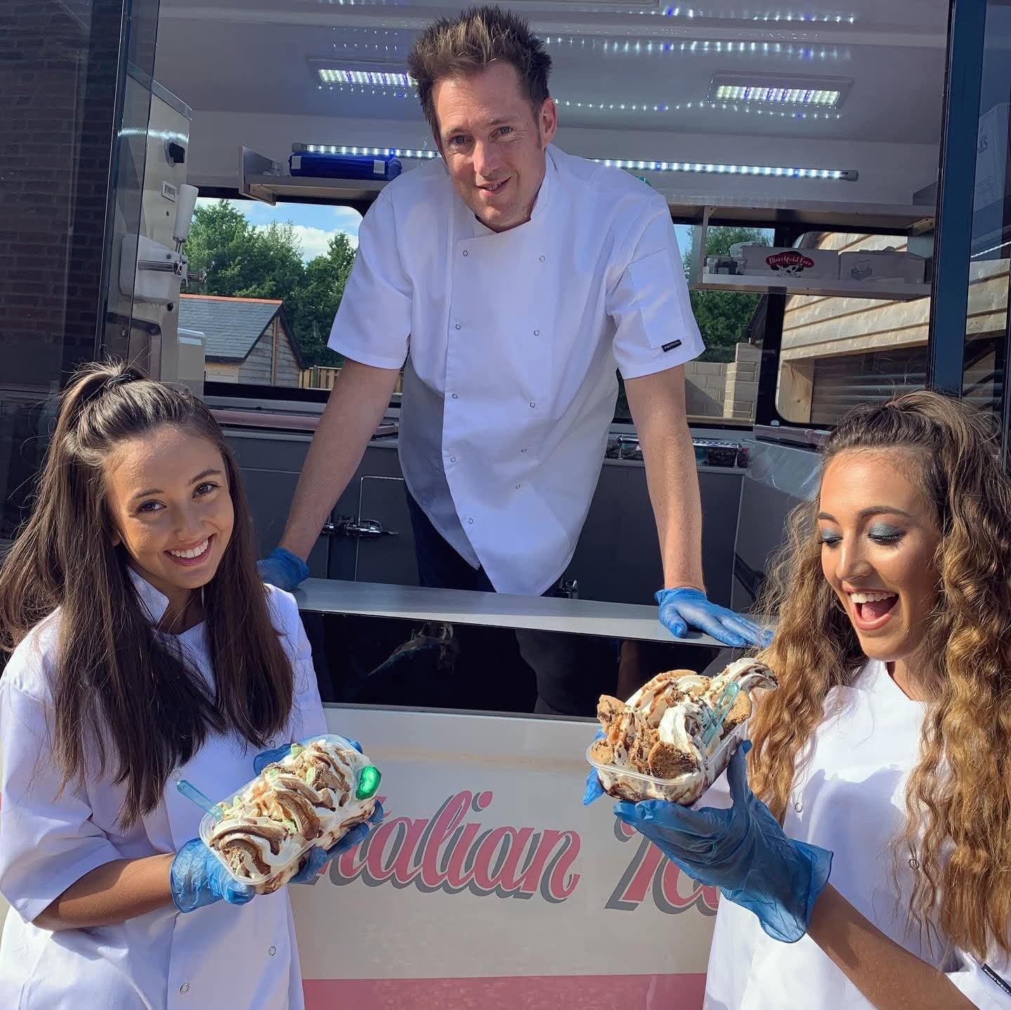 Three Hampshire Ices servers in white coats holding loaded ice cream tubs at the van hatch