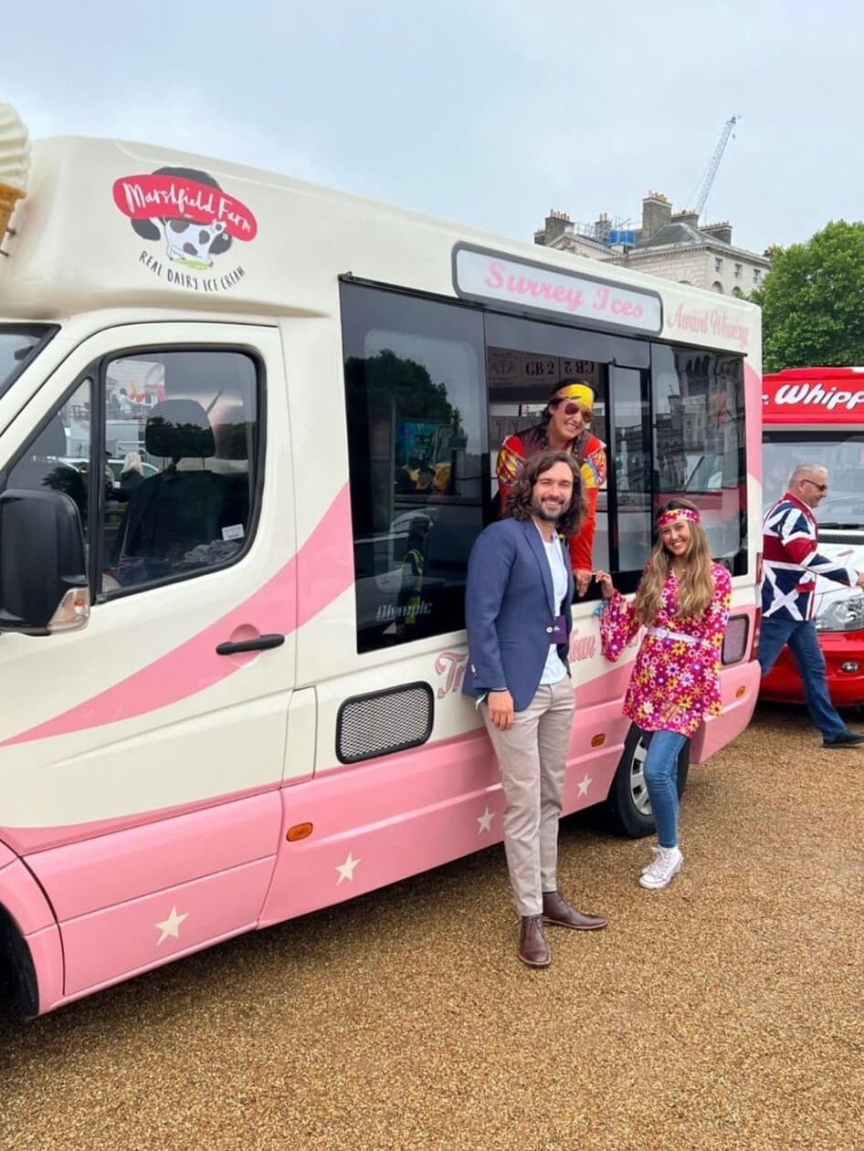 People standing beside a cream and pink Hampshire Ices van, with a red Mr Whippy van behind them